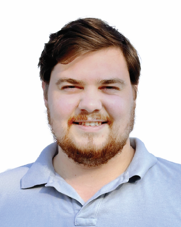 Smiling man in a light blue collared shirt.