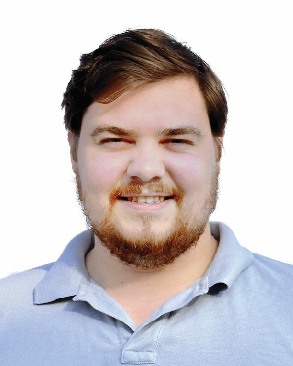 Smiling man in a light blue collared shirt.