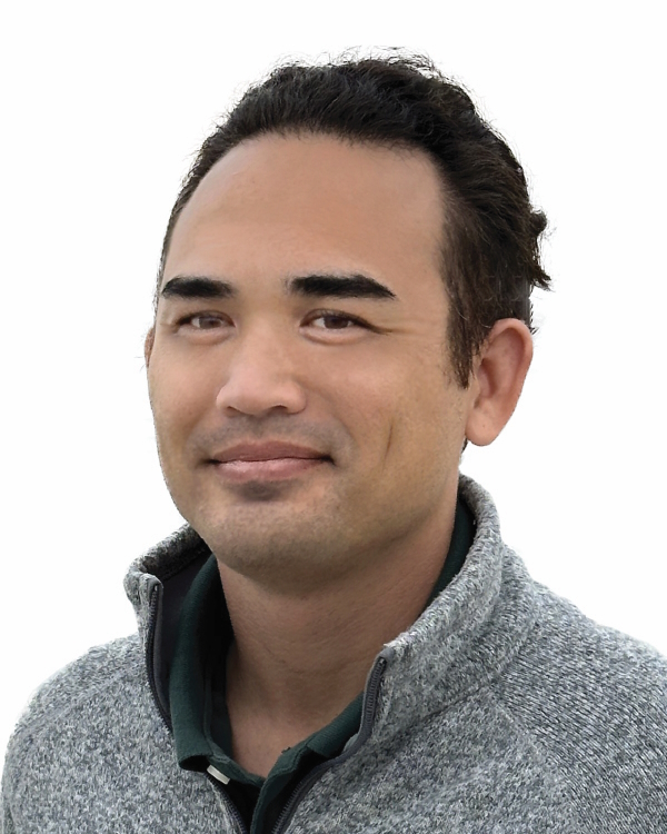 Man in gray sweater, neutral expression.